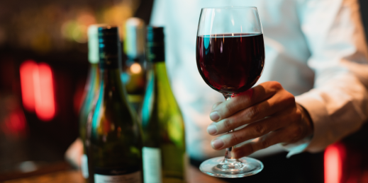 bartender-holding-glass-red-wine 1