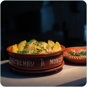 Taça de barro com bacalhau, batata, cebola e salsa, com inscrição “Bacalhau à Monção”.