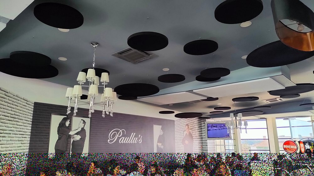 Interior do restaurante Paullu’s com teto decorativo, paredes com fotografias e ambiente moderno.