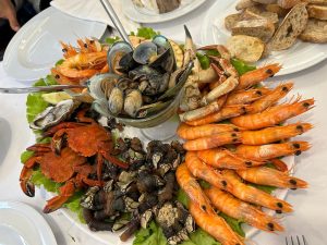 Travessa grande com camarão cozido, sapateira, percebes, amêijoas, ostras e limão.