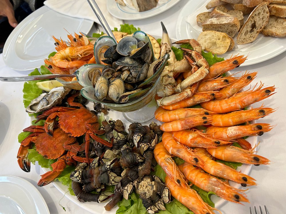 Travessa grande com camarão cozido, sapateira, percebes, amêijoas, ostras e limão.