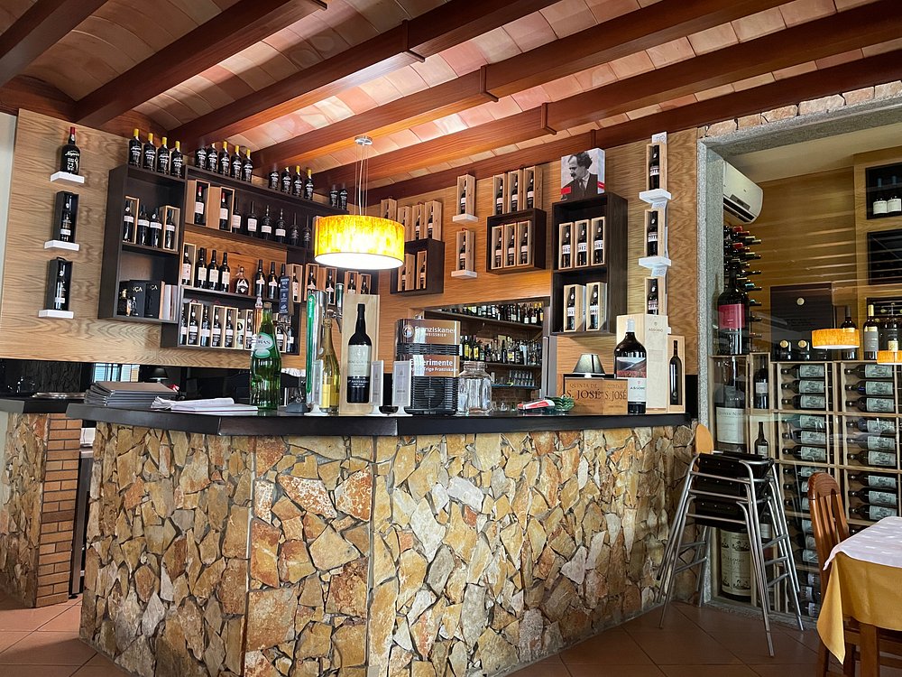 Interior do Solar O Condado com balcão de bar, garrafeira em madeira e várias garrafas expostas.