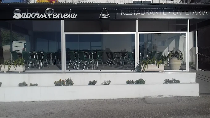 Vista frontal da fachada do restaurante Sabor a Penela, apresentando grandes janelas de vidro, área de esplanada coberta com mesas e toldo preto com letreiro.
