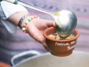 Grande panela com sopa tradicional a ferver e pessoas a servirem-se em tigelas no Festival das Sopas de Idanha-a-Nova.