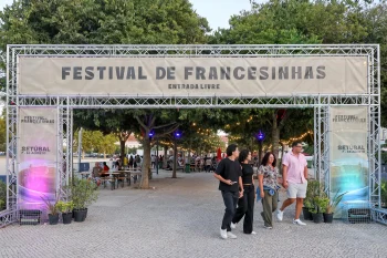 P&oacute;rtico met&aacute;lico do Festival de Francesinhas em Set&uacute;bal com pessoas na entrada.